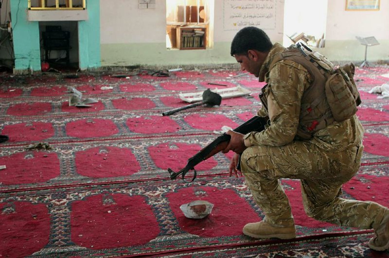 An Iraqi army soldier inspects the damage inside the Abu Bakr Mosque in Baqouba, northeast of Baghdad, Iraq, Friday, July 19, 2013. A bomb hidden in an air conditioner that ripped through a Sunni mosque during midday prayers and other attacks killed dozens in Iraq on Friday, extending a wave of violence targeting worshippers during the holy month of Ramadan.The violence is an extension of a surge of attacks that has roiled Iraq for months, reviving fears of a return to the widespread sectarian bloodshed that pushed the country to the brink of civil war after the 2003 U.S.-led invasion. (AP Photo)