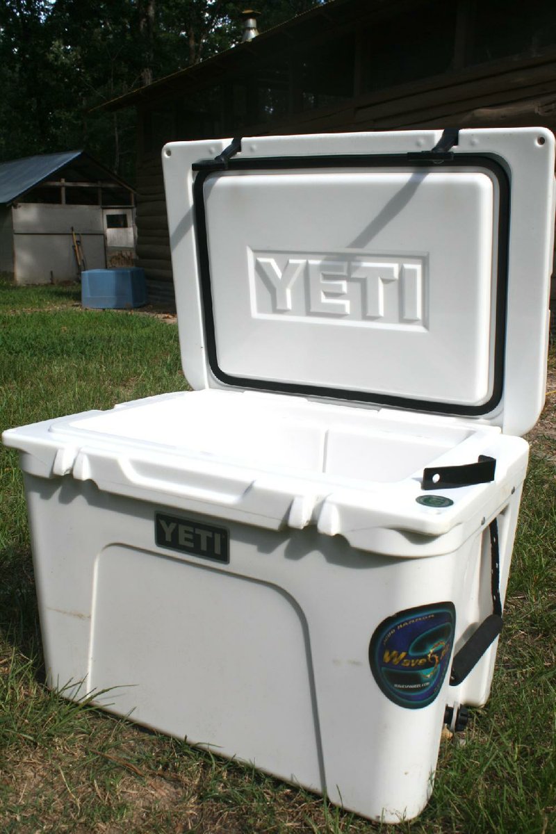 The Yeti Tundra 50 contained ice six hours longer than its closest competitor in our test. Notice the molded padlock holes at the outside corners of the lid. An aftermarket security kit comes with a shim (top right) that slides through the deck so it can be locked down with a special cable lock assembly. Note also the freezer grade gasket in the lid, which is standard on all elite level coolers. 