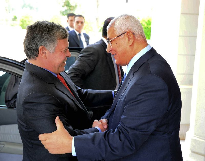 President Adly Mansour (right) welcomes Jordan’s King Abdullah to Egypt on Saturday. It was the first visit to Cairo by a head of state since Egypt’s recent coup. 