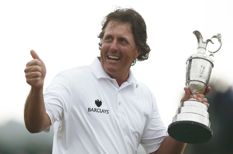 Phil Mickelson of the United States gestures as he holds up the Claret Jug trophy after winning the British Open Golf Championship at Muirfield, Scotland, Sunday July 21, 2013.  (AP Photo/Matt Dunham)