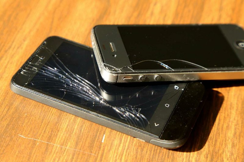 7/17/13
Arkansas Democrat-Gazette/STEPHEN B. THORNTON
An HTC phone, bottom and an iPhone, top, with broken screens for a business story of expenditures on smartphone screen repair.