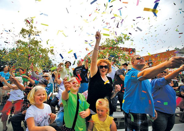 Tinley Boysen, 8, from left, Taryn Boysen, 10, Tielyr Boysen and their parents Laura and Travis Boysen, all of Rogers, participate in the traditional confetti toss Aug. 24 to officially open the Frisco Festival in downtown Rogers. 