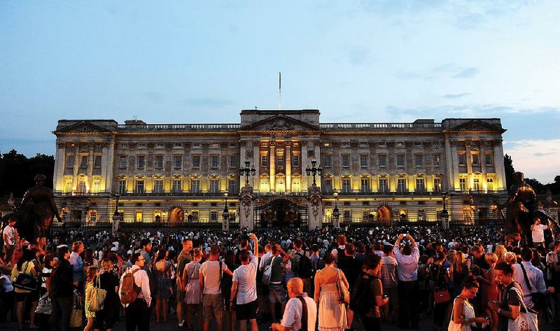 Members of the public celebrate outside Buckingham Palace after an easel was placed in the forecourt of the Palace with the notification to announce the birth of a baby boy, at 4.24pm to the Duke and Duchess of Cambridge at St Mary's Hospital in west London, Monday July 22, 2013.(AP Photo/Clive Gee, PA) UNITED KINGDOM OUT - NO SALES - NO ARCHIVES