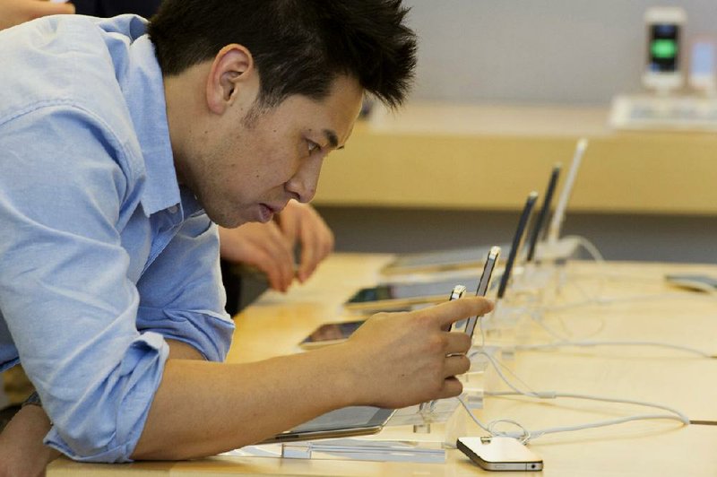 A customer looks at an Apple Inc. iPhone 5 displayed at the Apple store in Hong Kong on July 17. Apple said Tuesday that its quarterly revenue was $35.3 billion, beating analyst estimates. 