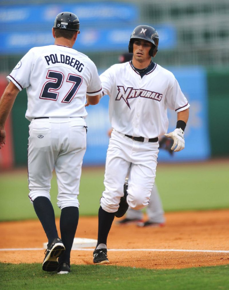Northwest Arkansas center fielder Brett Eibner rounds third base and is congratulated by Manager Brian Poldberg after hitting a home run in the first inning of the Naturals’ game against the Arkansas Travelers on Tuesday at Arvest Ballpark in Springdale. The game was suspended by rain in the 10th inning with the score tied at 8-8 and will be completed before today’s regularly scheduled game. 