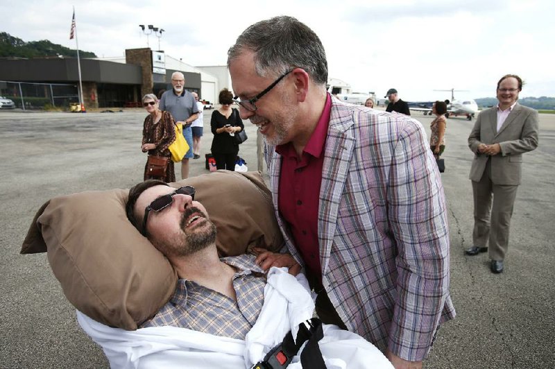 James Obergefell (right) and John Arthur return to Cincinnati July 11 after they were married on a plane on the tarmac at Maryland’s Baltimore/Washington International Thurgood Marshall Airport. Same-sex marriage is recognized in Maryland. 