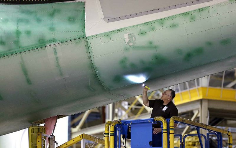 A Boeing employee inspects the underside of a Boeing 747 at the company’s production plant in Everett, Wash., in May. Boeing’s second-quarter net income rose 13 percent to $1.09 billion, the company said Wednesday. 