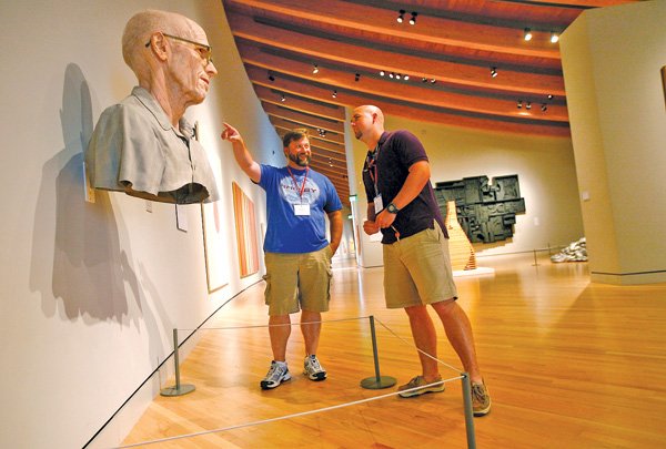 Brian Robbins, left, a teacher from Elkins High School, and Paul Burkhead, a teacher from Newport High School, look over art Wednesday at Crystal Bridges Museum of American Art in Bentonville. About 50 AP teachers toured and took notes through the museum as part of the AP Summer Institute, a training program for high school AP teachers hosted by the University of Arkansas. 