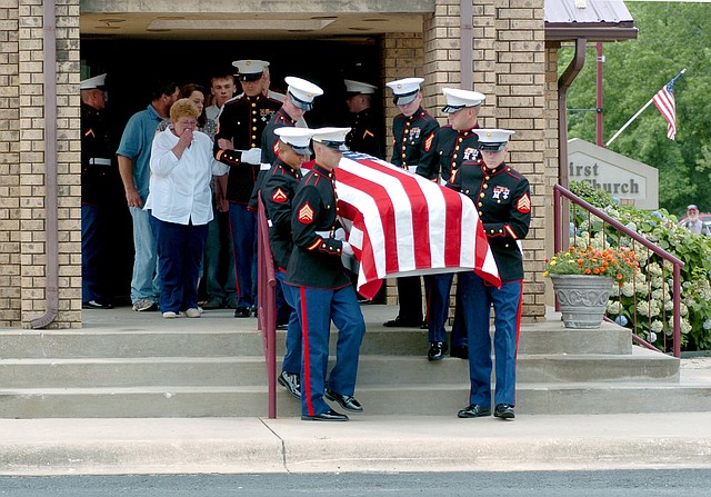 Marines carry the casket of U.S. Marine Corps Lance Cpl. Benjamin Tuttle
from the church following Thursday's funeral service at First Baptist
Church in Gentry. Tuttle's grandmother and adoptive mother, Faye Tuttle,
weeps as she is escorted by another Marine.