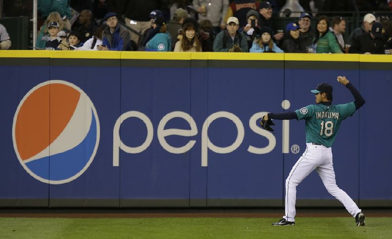 In this Friday, April 12, 2013, photo, Seattle Mariners starting pitcher Hisashi Iwakuma warms up next to a Pepsi advertisement before a baseball game against the Texas Rangers, in Seattle. PepsiCo Inc. reports quarterly financial results before the market opens on Wednesday, July 24,2013. (AP Photo/Ted S. Warren)