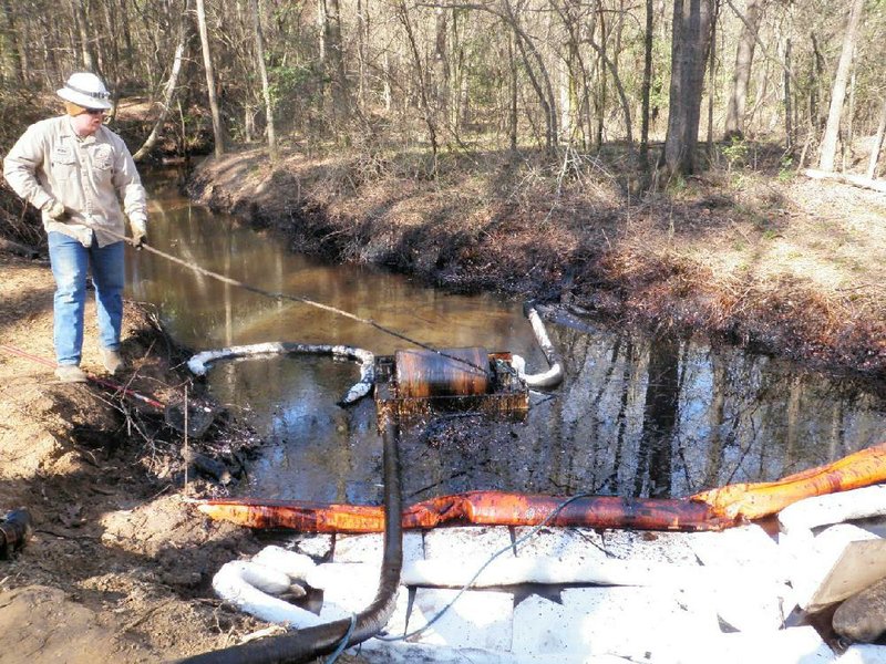 A worker mops up crude oil during the cleanup of a spill at a Lion Oil pumping station near Magnolia in this photograph taken March 12 and provided by the U.S. Environmental Protection Agency. 