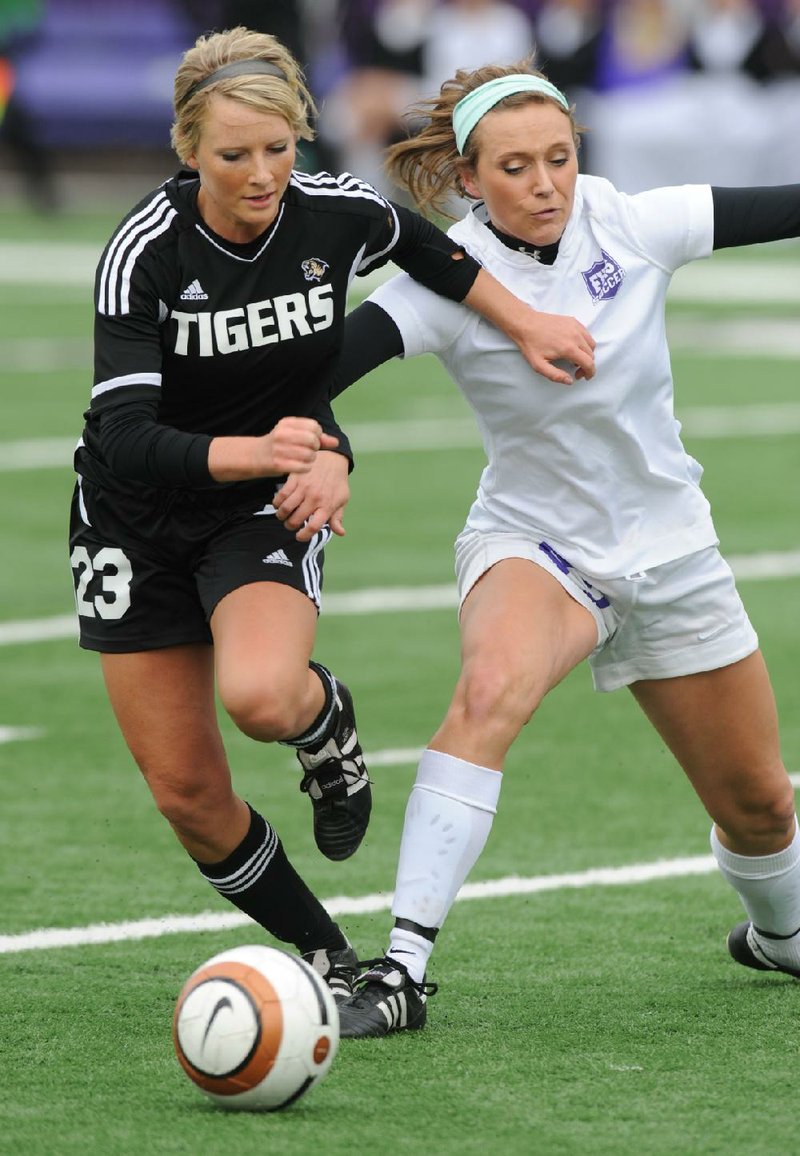 STAFF PHOTO ANDY SHUPE
Bentonville's Dyann Shade (23) and Fayetteville's Ellie Breden vie for the ball Friday, May 3, 2013, during the first half of play at Harmon Stadium in Fayetteville.