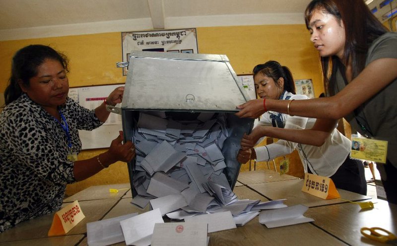 Election officials open a ballot box for counting at a polling station at Chadomouk High School, in Phnom Penh, Cambodia, Sunday, July 28, 2013. Cambodians went to the polls Sunday in an election almost certain to deliver another mandate for long-ruling Prime Minister Hun Sen amid cries of foul play by his opponents. (AP Photo/Heng Sinith)