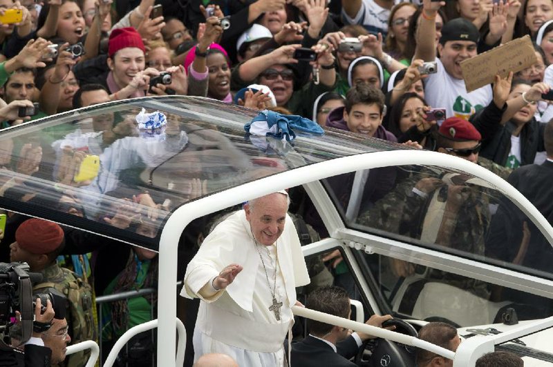 Pope Francis waves from his popemobile along the Copacabana beachfront on his way to celebrate the World Youth Day's closing Mass in Rio de Janeiro, Brazil, Sunday, July 28, 2013. Hundreds of thousands of young people slept under chilly skies in the white sand awaiting Francis' final Mass for WYD. (AP Photo/Victor R. Caivano)