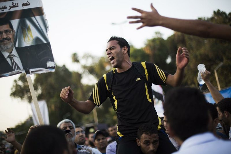 Supporters of Egypt's ousted President Mohammed Morsi chant slogans supporting the former leader during a protest near Cairo University in Giza, Egypt, Sunday, July 28, 2013. Setting the stage for more confrontation, the military-installed interim president, Adly Mansour, gave Prime Minister Hazem el-Biblawi the power to grant the military the right to arrest civilians in what government officials said could be a prelude to a major crackdown on Morsi's supporters or Islamic militants who have stepped up attacks against security forces in the Sinai Peninsula. (AP Photo/Manu Brabo)