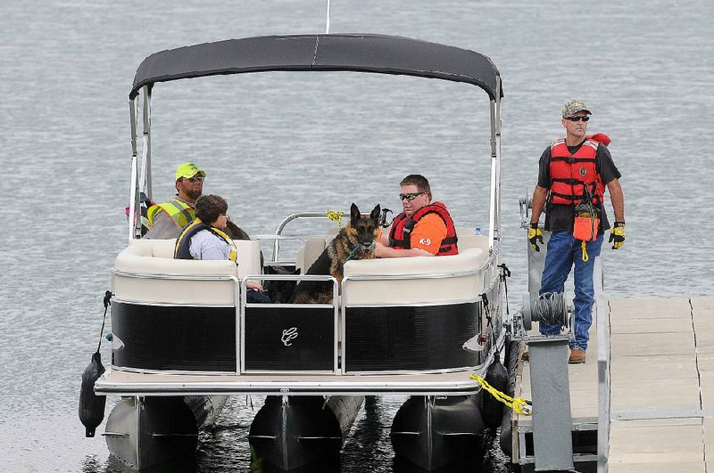 STAFF PHOTO SAMANTHA BAKER w @NWASamantha
Cadaver dogs from St. Louis and their handlers board a boat in order to search for the body of Michael Burton of Omaha, Neb. Monday, July 29, 2013, at Beaver Lake near Dam Site Park in Eureka Springs. Burton was spearfishing with a friend on Saturday and never surfaced. Carroll County Sheriff's Department and local search teams assisting in the recovery are using cadaver dogs, sonar and dive teams to locate the Burton's body.