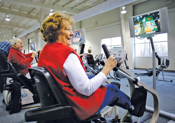 Brenda Hutchinson of Rogers uses a cross trainer workout machine in February at the Adult Wellness Center in Rogers. 