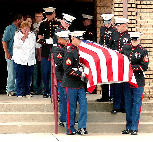 Marines carry the casket of U.S. Marine Corps Lance Cpl. Benjamin Tuttle from the church following Thursday’s funeral service at First Baptist Church in Gentry. Tuttle’s grandmother and adoptive mother, Faye Tuttle, weeps as she is escorted by Marine Sgt. Cheek, of Tulsa, Okla. 