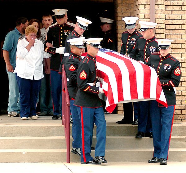 Marines carry the casket of U.S. Marine Corps Lance Cpl. Benjamin Tuttle from the church following Thursday’s funeral service at First Baptist Church in Gentry. Tuttle’s grandmother and adoptive mother, Faye Tuttle, weeps as she is escorted by Marine Sgt. Cheek, of Tulsa, Okla. 