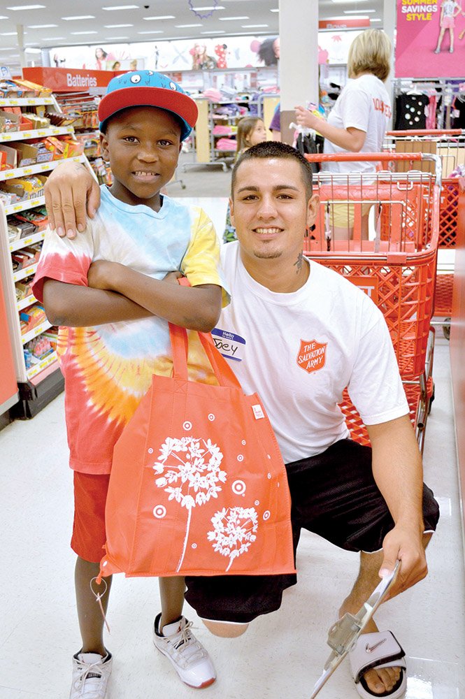 Troy Wiseman Jr., 9, of Conway finishes shopping at Target with The Salvation Army Conway Corps volunteer Joey Federico, 25, of Conway. Troy bought clothes and the cap he’s wearing. Target in Conway participated in the nationwide back-to-school shopping event in a partnership with The Salvation Army. Selected students were given $80 gift cards to buy clothes or supplies.