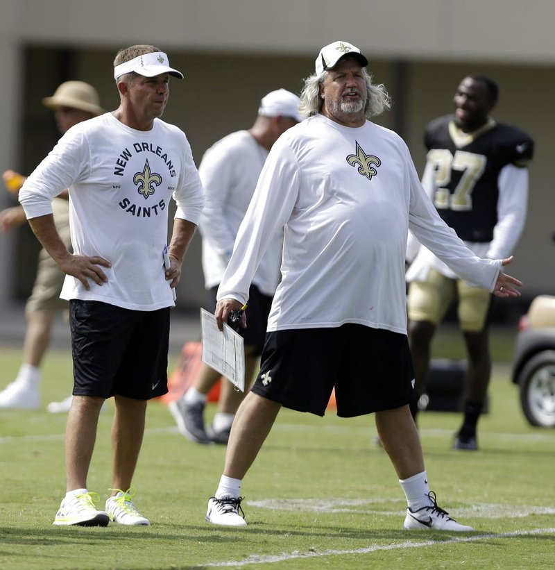 FILE - In this July 30, 2013, file photo, New Orleans Saints head coach Sean Payton and defensive coordinator Rob Ryan chat during NFL football training camp in Metairie, La. Saints defensive players are praising their new defensive coordinator not just for his aggressive, fun-loving approach, but also for his genuine interest in players' opinions about what works best for them. (AP Photo/Gerald Herbert, File)