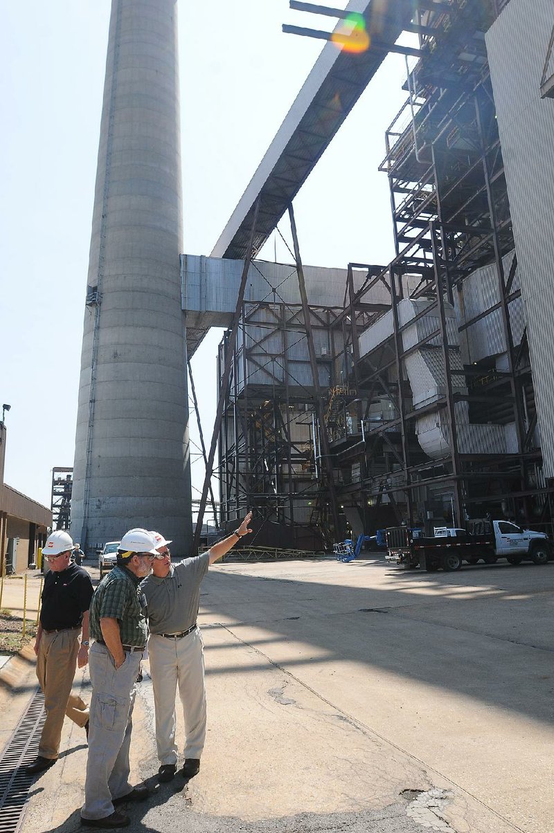 Plant Manager Carl Handley, right, describes the Flint Creek Power Plant in Gentry for several visitors during a 2012 plant tour. The Flint Creek plant is one of three coal-fired stations in Arkansas that are improving their environmental controls to reduce emissions. 