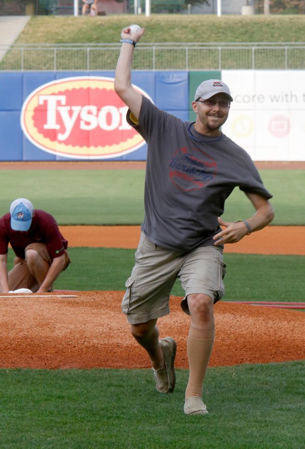 Jason Bertschy, former Bentonville resident and minor league umpire, throws out the first pitch at Arvest Ballpark in Springdale on June 26 prior to the Northwest Arkansas Naturals game against the Midland RockHounds. 
