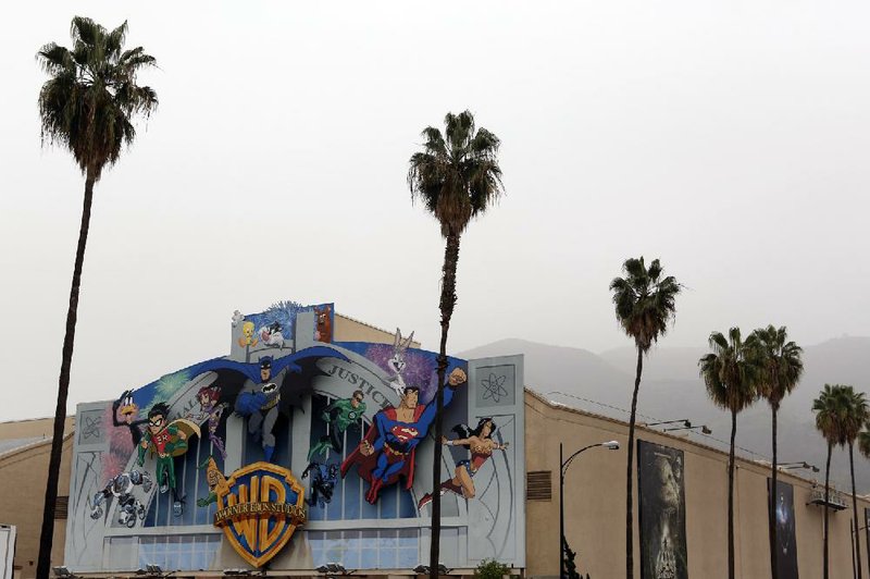 Cartoon characters are displayed on a mural at Warner Bros. Studios in Burbank, Calif., in February. Warner Bros.’ parent company, Time Warner Inc., earned $771 million, or 81 cents per share in the April-June quarter. 