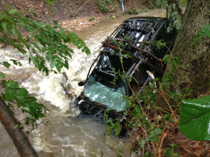 A vehicle in a creek behind stores in Gateway off of U.S. 62 following flooding Thursday.