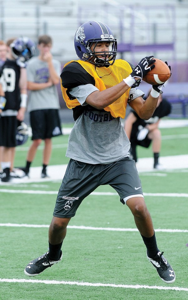 Jordan Dennis of Fayetteville catches the ball during passing drills Friday at Harmon Stadium in Fayetteville. 