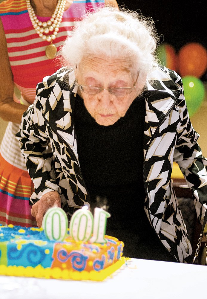 Florrie Lyle blows out her birthday candles during a community celebration for her 100th birthday at the Bob Herzfeld Memorial Library in Benton. As a child, she rang a bell to tell the community the news about the end of World War I in 1918, and she was a teacher at the Japanese internment camps in the 1940s. She also taught career classes at Benton High School.