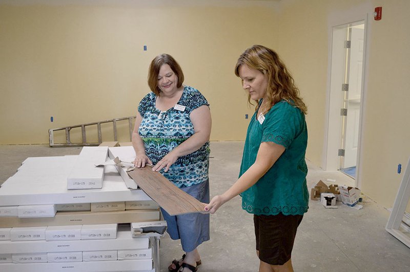 Judi Lively, left, executive director of Bethlehem House, and Jill Imboden, development coordinator, look over laminate in the dining room of the two-story shelter that is nearing completion at 1115 Parkway Ave. in Conway. A capital campaign finished in 2012 was successful, but the project is estimated to cost about $80,000 more than expected, Lively said.