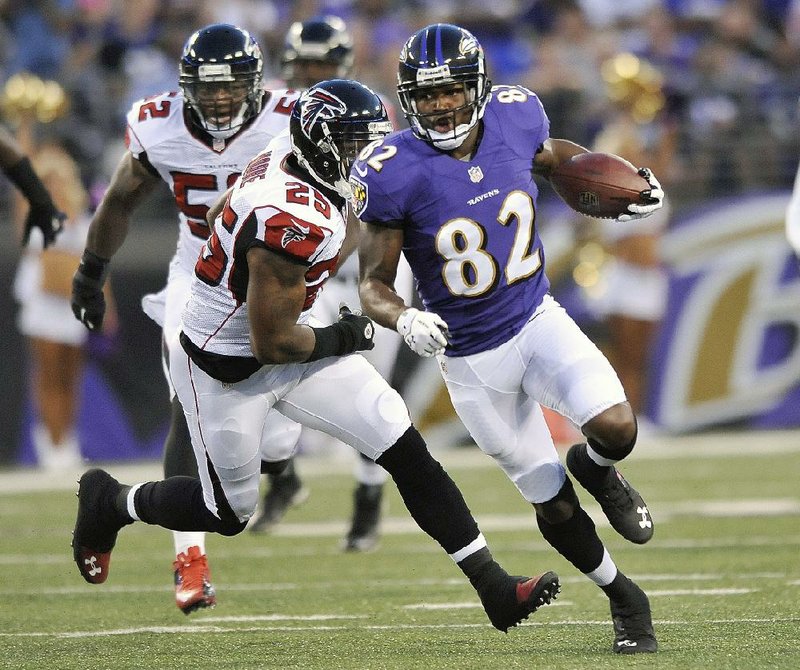 Baltimore Ravens wide receiver Torrey Smith carries the ball past Atlanta Falcons strong safety William Moore for a touchdown during the first half of a preseason NFL football game in Baltimore, Thursday Aug. 15, 2013. (AP Photo/Gail Burton)