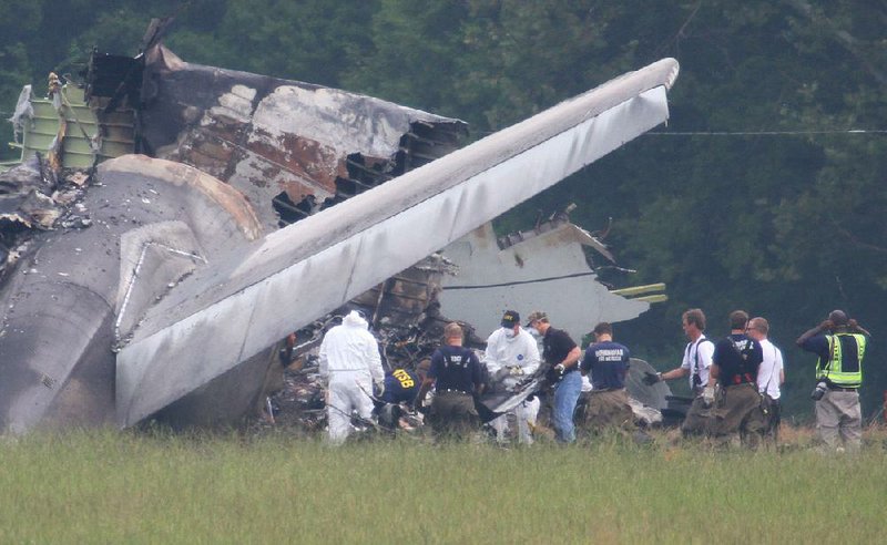 NTSB investigators remove a large piece of debris from the tail section of the UPS cargo plane that crashed Wednesday on approach to the Birmingham-Shuttlesworth International Airport August 15,  2013 in Birmingham, Ala. Investigators found flight recorders on Thursday that could hold important clues about why the UPS jet crashed at Birmingham's airport, killing two pilots. (AP Photo/Hal Yeager)