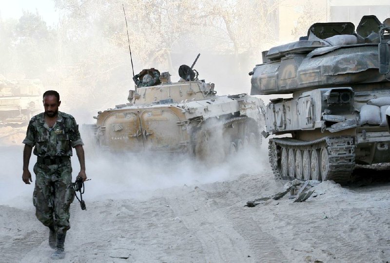 Syrian forces patrol a street Saturday in the Jobar neighborhood of Damascus during a government-sponsored media tour. 
