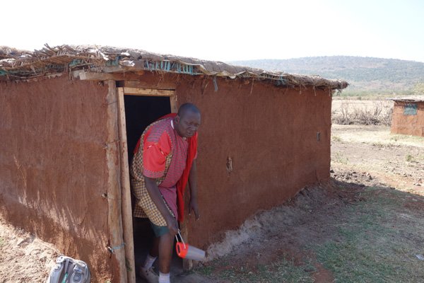 Photo by Lowell Grisham
Host James ole Lesaloi emerges from one of the huts in a Maasai village in Kenya.
