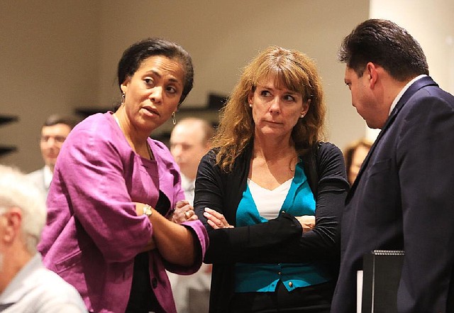 Arkansas Democrat-Gazette/RICK MCFARLAND --08/26/13--   ExxonMobile representatives' Johnita Jones (left), Pipeline Risk and Integrity manager, Karen Tyrone, vice president for southern operations, Nick Medina, Public and Government Affairs manager for the Middle East and Russia, confer before a meeting with Metroplan in Little Rock concerning pipeline integrity following the pipeline rupture and spill in Mayflower last March.