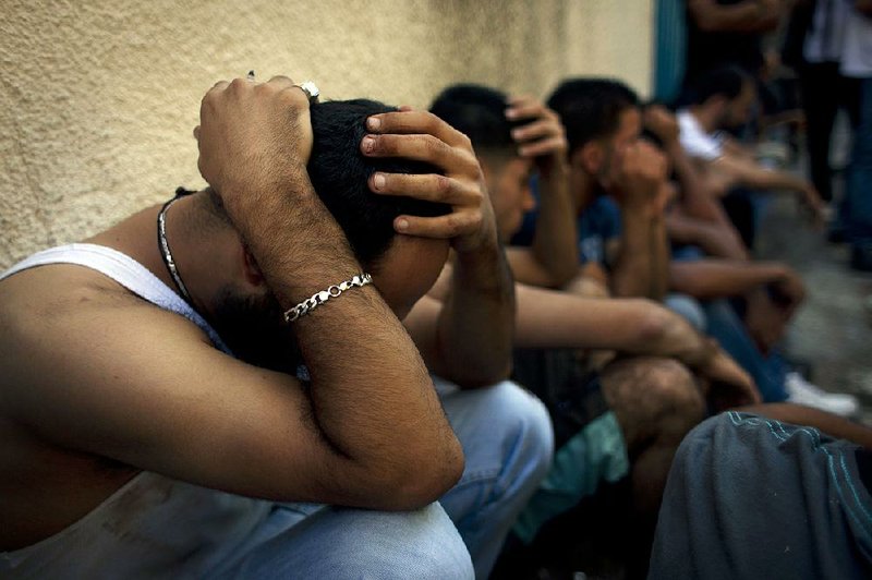 Palestinian mourners grieve while waiting for the funeral procession out side the morgue of the main hospital at the West Bank town of Ramallah, Monday, Aug. 26, 2013. Israeli soldiers killed three Palestinians in clashes during an arrest raid in the West Bank, a Palestinian official and the Israeli military said Monday, in the deadliest incident in the area in years. (AP Photo/Nasser Nasser)