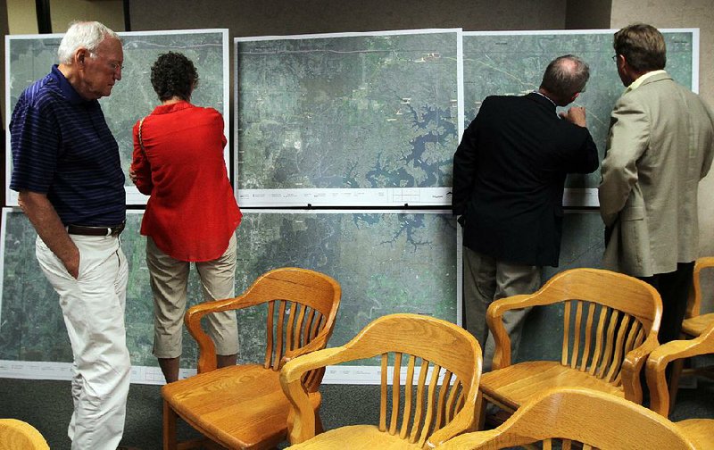 Arkansas Democrat-Gazette/BENJAMIN KRAIN --08/26/2013--
Benton County land owners Cris CQ and Elenor Jones, left, examine a map of a proposed SWEPCO power line route which cuts through their property as Glenn Crenshaw, a distressed property expert from Eureka Springs and Jonathan Wiltsie, a SWEPCO sub-contractor, right, discuss property lines in Carroll County during a hearing about the power line construction project at the Public Service Commission in Little Rock on Monday.