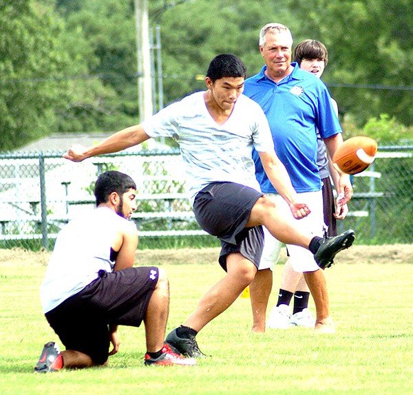 Allan Castaneda (left) held the football for kicker, Meng Vang (center). As the football began its ascent toward the goal post, head football coach, Shane Holland, analyzed Vang’s technique. Holland put his players through their paces during practice Aug. 19 in Bulldog Stadium. The first game will be a benefit match with Gentry on Aug. 29, at Decatur.