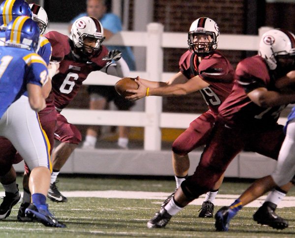 Springdale High School sophomore quarterback Fuller Chandler (19) hands off to senior running back Deandre Murray (6) during a scrimmage against Mountain Home Tuesday, Aug. 27, 2013 at Jarrell Williams Bulldog Stadium in Springdale.