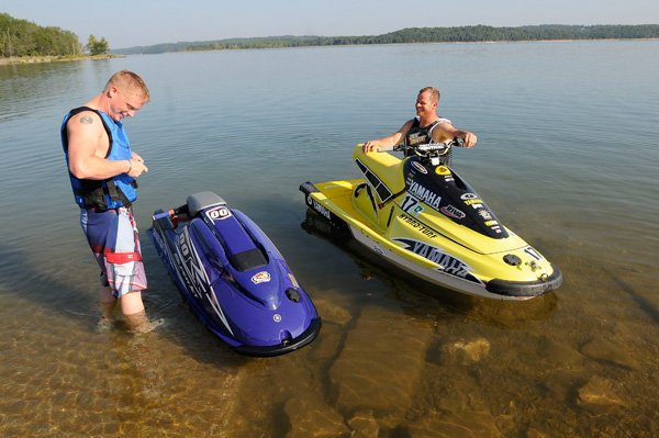 Robb Morgan, left, buckles his life jacket before he and Andy Judkins ride their personal watercraft at Beaver Lake on Friday Aug. 30 2013. The men, both of Rogers, launched at the Arkansas 12 bridge boat ramp.