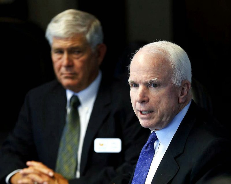 U.S. Sen. John McCain, R-Ariz., right, speaks during a roundtable discussions with the Greater Phoenix Economic Council and the Arizona Small Business Association, Wednesday, Aug. 28, 2013 in Phoenix. (AP Photo/Matt York)