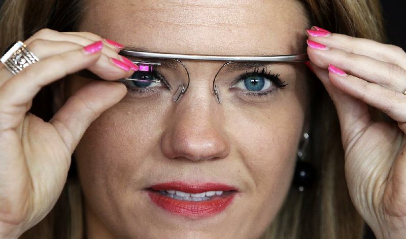 FILE - In this Wednesday, May 29, 2013 file photo, Sarah Hill, a Google Glass contest winner, of Columbia, Mo., tries out the device, in New York. “This is like having the Internet in your eye socket,” Hill said. “But it’s less intrusive than I thought it would be. I can totally see how this would still let you still be in the moment with the people around you.” (AP Photo/Frank Franklin II, File)