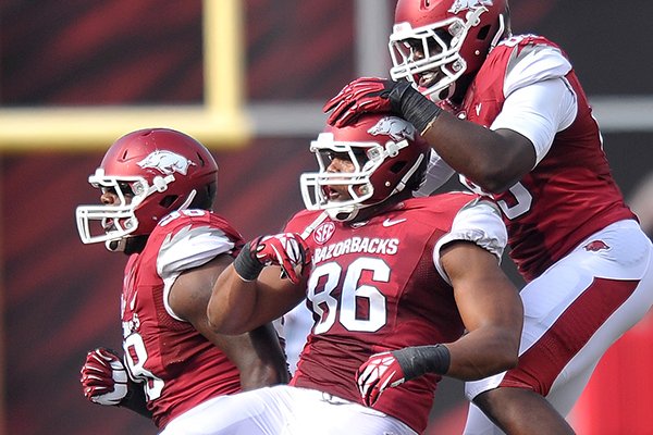 Arkansas defenders (left to right) Robert Thomas, Trey Flowers and Brandon Lewis celebrate after a turnover during Saturday afternoon's game against Louisiana-Lafayette at Razorback Stadium in Fayetteville.