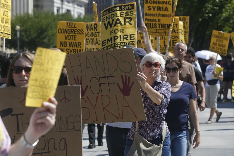 Anti-war demonstrators protest against possible U.S. military action in Syria in front of the White House in Washington, Saturday, Sept. 7, 2013. (AP Photo/Charles Dharapak)