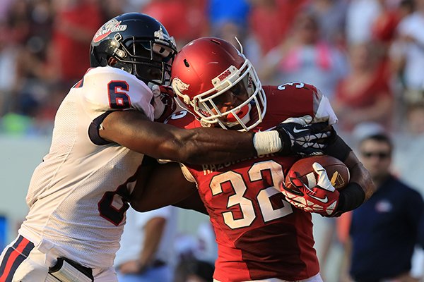 Arkansas's Jonathan Williams (32) is caught after a long run by Samford's Jaquiski Tartt (6) during their game at War Memorial Stadium in Little Rock Saturday.