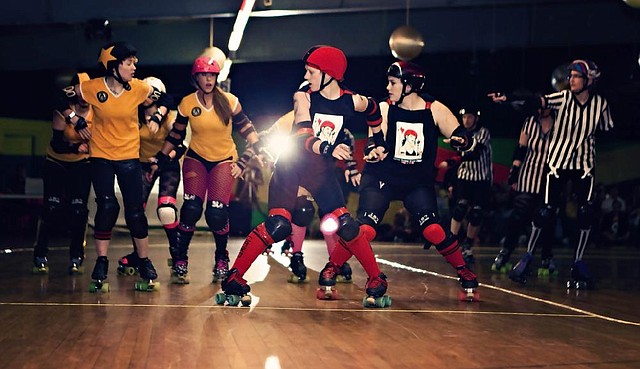 Special to the Democrat-gazette/JENNIFER WHEELER - Central Arkansas Roller Derby blockers (in black) Rachael Green and Samantha Boyce ("Obsessive Cherry Disorder") prepare to defend against Girls Rolling in the South, while Kristen Pope (Krispy Stick, in stripes) referees on the sideline.