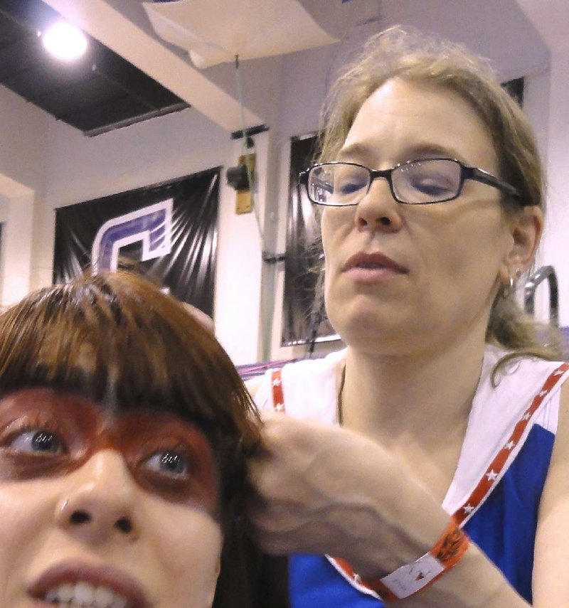 Special to the Democrat-Gazette/ERIC FRANCIS
Leslie Garrett braids a player's hair before a Gotham Girls Roller Derby bout in May in New York. A former blocker for Central Arkansas Roller Derby in Little Rock, Garrett is the Gotham Girls' bout manager.                               