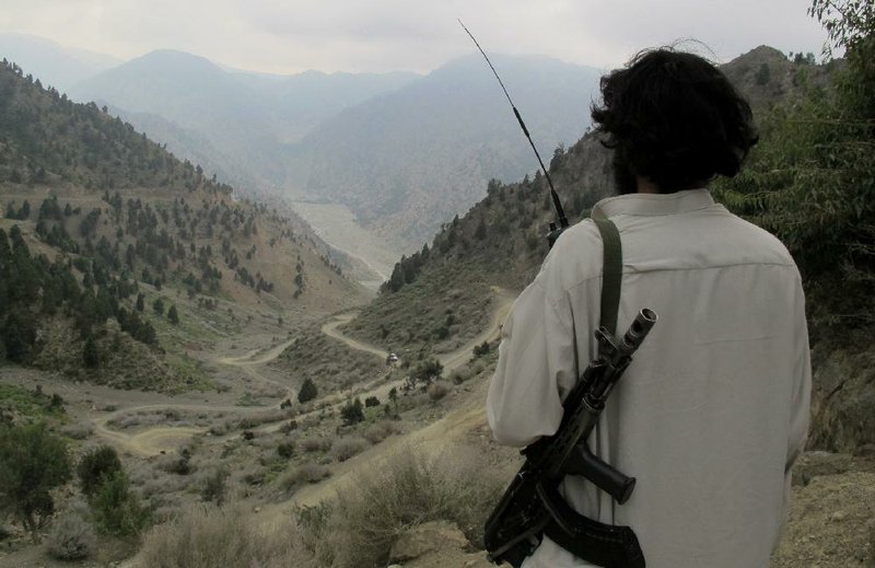 A Pakistani Taliban militant watches movement on the main road of Shawal in the tribal region of North Waziristan. Thousands of militants in the region bordering Afghanistan are reportedly training for a possible civil war in Afghanistan after foreign forces withdraw. 